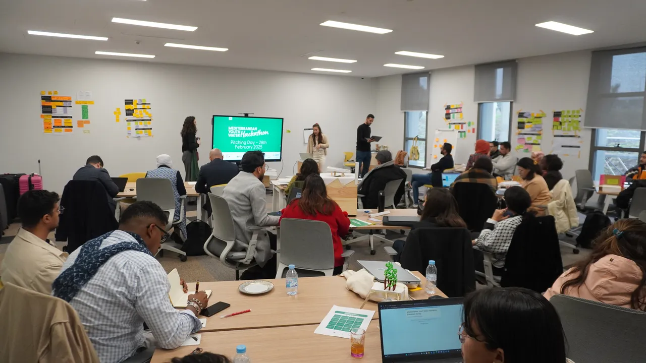 Salle d'idéation d'un hackathon de l'EIC avec équipes et murs de post-it